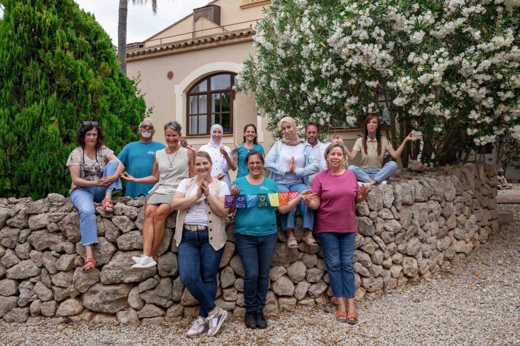 Gruppe von Menschen vor Blumenwand.
